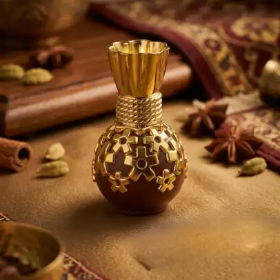 A Majestic Blend of Tradition and Luxury. Step into a world of royal aromas with our Royal Golden Glow Attar. Housed in an exquisitely designed chocolate-brown and golden-filigree bottle, this 20ml premium attar is a tribute to India's rich olfactory heritage. Its deep, captivating fragrance is designed for those who appreciate the finer things in life, making it a perfect companion for both spiritual gatherings and special occasions. What Makes It Extraordinary? Pure & Alcohol-Free: A high-quality oil-based concentrate that is kind to your skin and stays true to its scent for hours. Intricate Designer Bottle: The ornate golden bottle is a piece of art itself, making it a stunning addition to your collection or an unforgettable gift. Rich, Long-Lasting Scent: Carefully blended to provide a lasting aroma that evolves beautifully throughout the day. Spiritual & Personal Use: Ideal for applying during meditation to enhance focus, or as a signature personal fragrance.